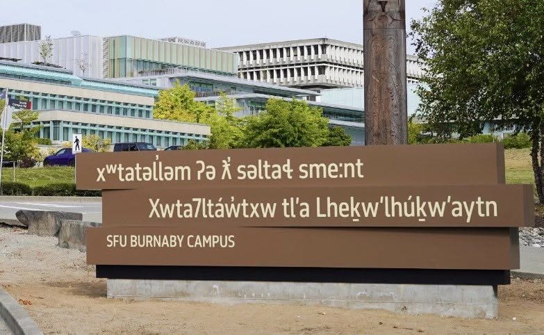 SFU Burnaby campus sign with two Indigenous-language lines above a smaller English SFU BURNABY CAMPUS line